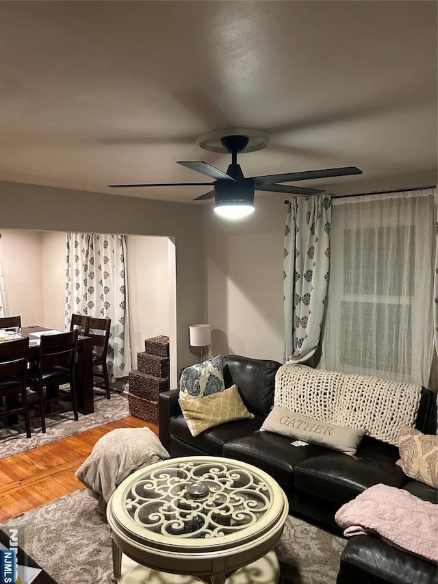 living room featuring hardwood / wood-style floors and ceiling fan