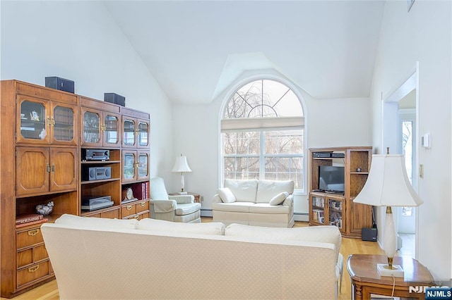 living room featuring high vaulted ceiling, light hardwood / wood-style floors, and baseboard heating