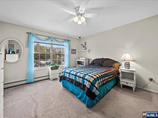 carpeted bedroom with ceiling fan and baseboard heating