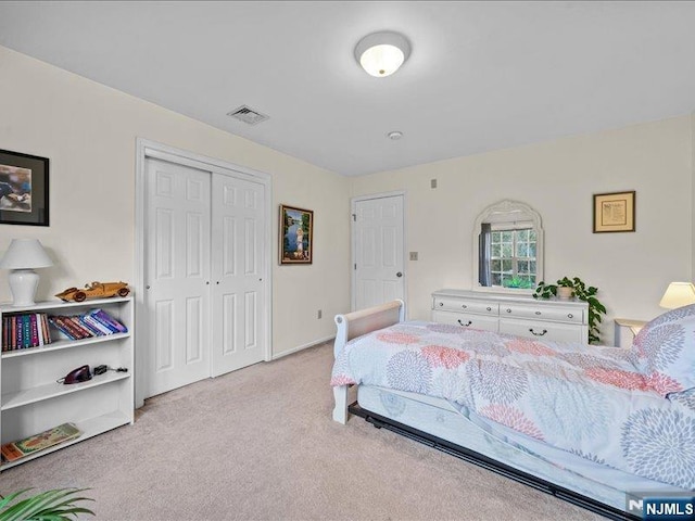 bedroom with light colored carpet and a closet