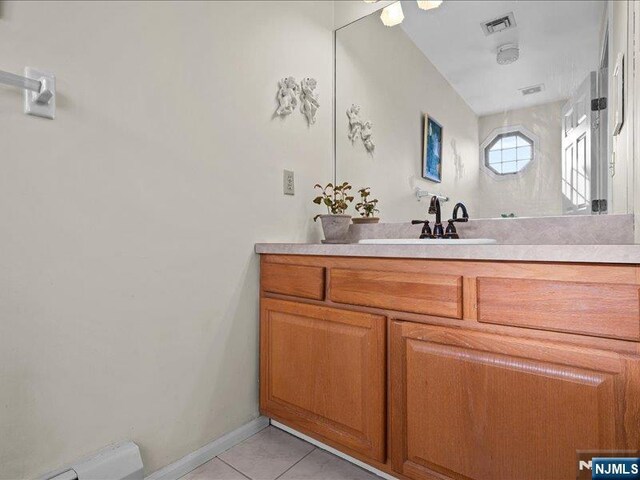 bathroom with tile patterned flooring, vanity, and baseboard heating