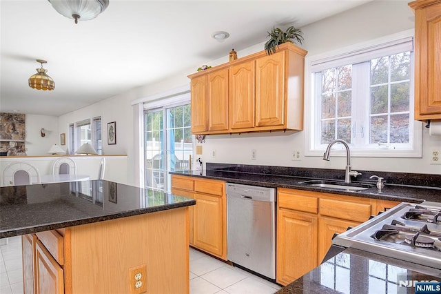 kitchen featuring sink, stainless steel dishwasher, a center island, and dark stone counters