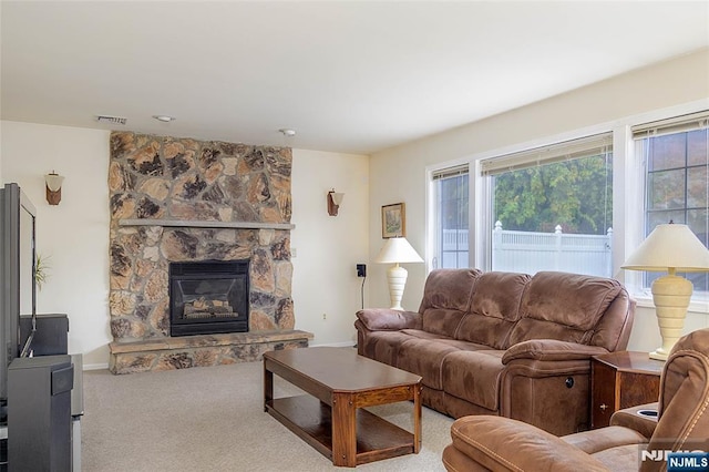 living room featuring a stone fireplace and carpet floors