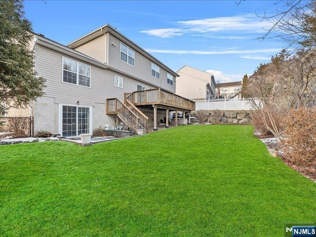 back of house featuring a yard and a deck