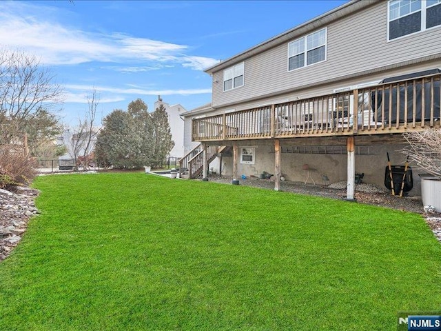 rear view of house with a deck and a lawn