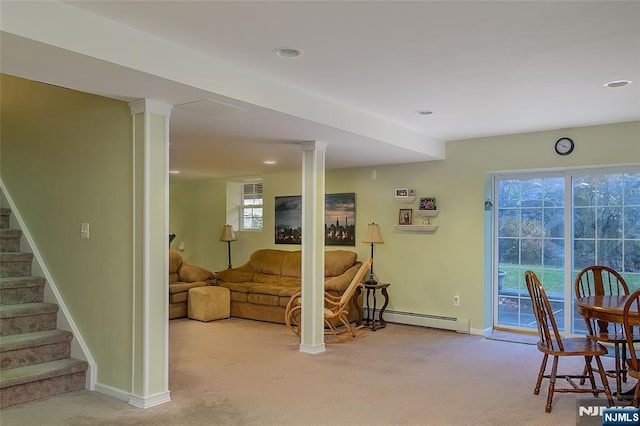 carpeted living room with a baseboard heating unit, plenty of natural light, and ornate columns