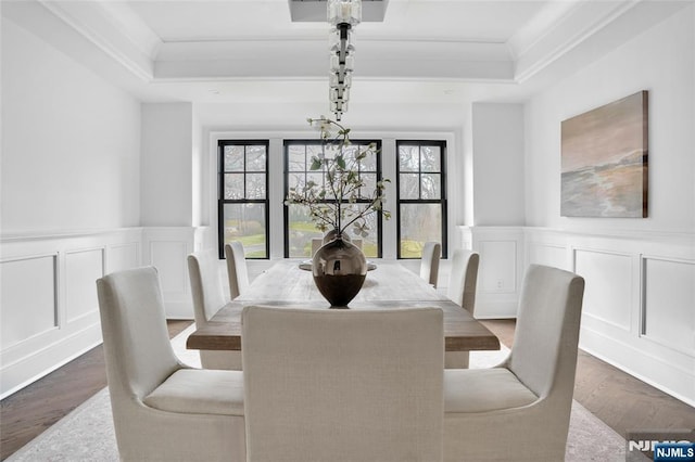 dining room featuring crown molding, dark hardwood / wood-style floors, and a raised ceiling