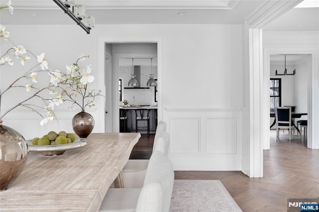 dining space featuring ornamental molding and dark parquet flooring