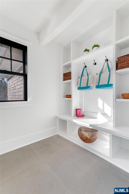 mudroom featuring built in features, a wealth of natural light, tile patterned floors, and beam ceiling