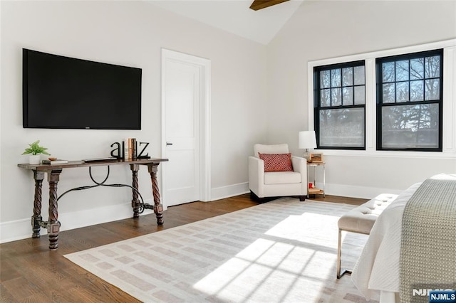 living area featuring vaulted ceiling, dark hardwood / wood-style floors, and ceiling fan