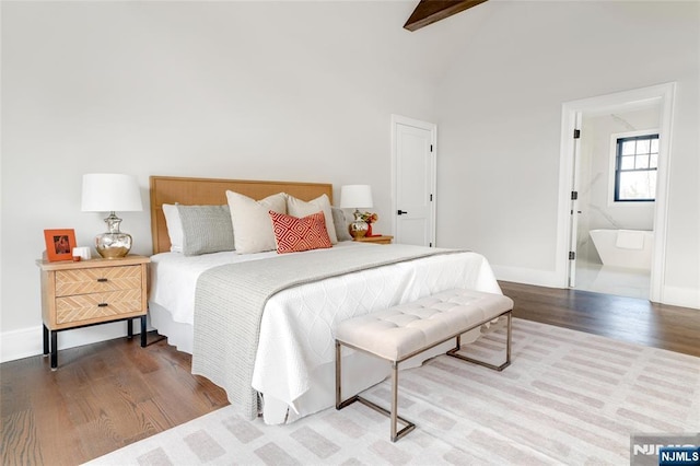 bedroom featuring ensuite bathroom, high vaulted ceiling, hardwood / wood-style floors, and beam ceiling