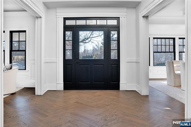 entryway with dark parquet flooring