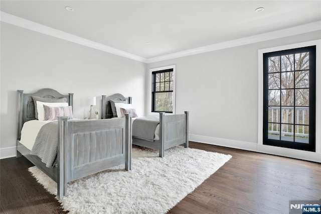 bedroom featuring crown molding and dark hardwood / wood-style floors