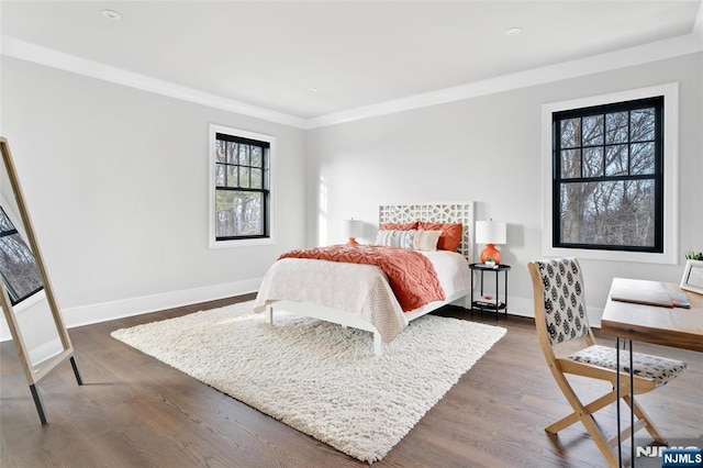 bedroom with dark hardwood / wood-style flooring and crown molding