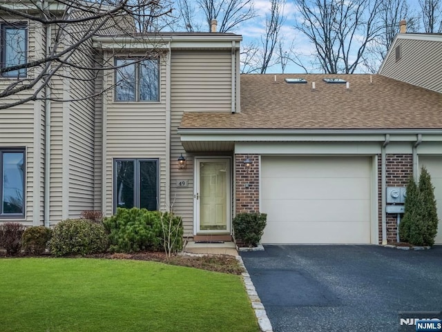 view of property with a garage and a front yard