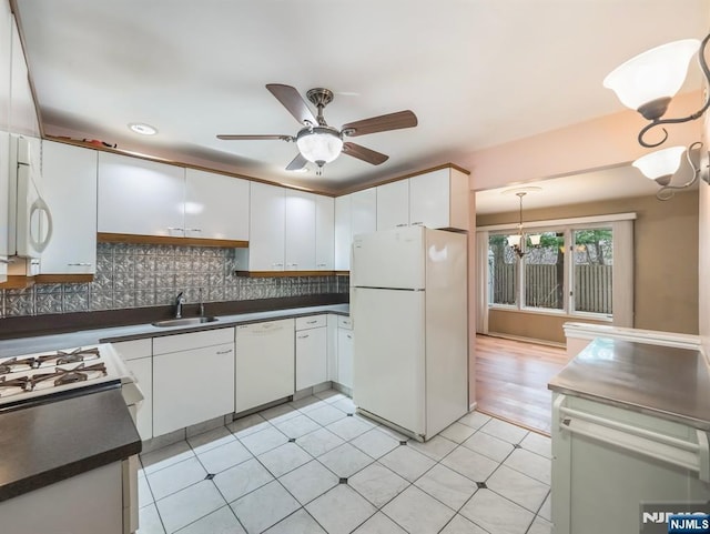 kitchen with sink, white cabinetry, tasteful backsplash, white appliances, and ceiling fan with notable chandelier