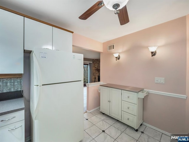 kitchen featuring white cabinetry, light tile patterned floors, ceiling fan, and white refrigerator