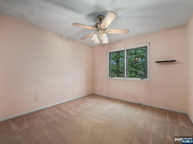 spare room featuring ceiling fan and light carpet