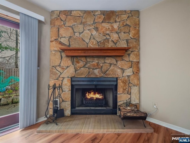 interior details featuring wood-type flooring and a stone fireplace