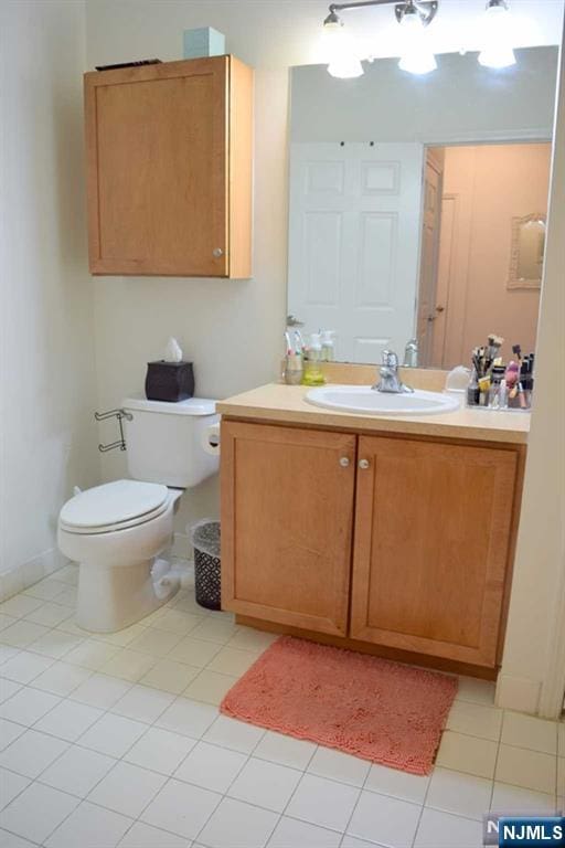 bathroom featuring tile patterned flooring, vanity, and toilet