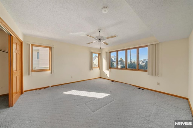 interior space featuring ceiling fan, carpet, and a textured ceiling