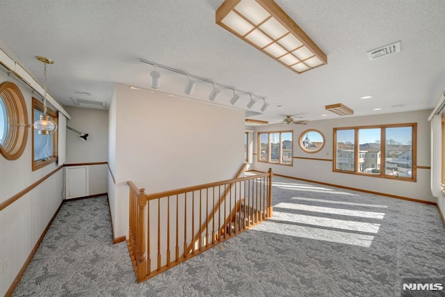 stairs with carpet and a textured ceiling