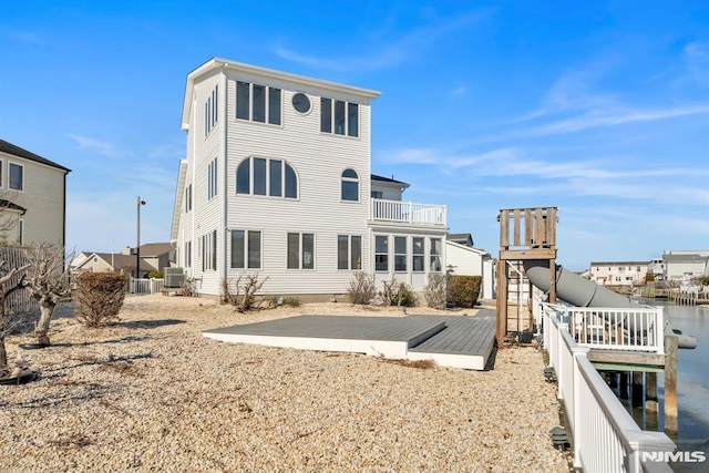 rear view of property featuring a deck with water view and central AC