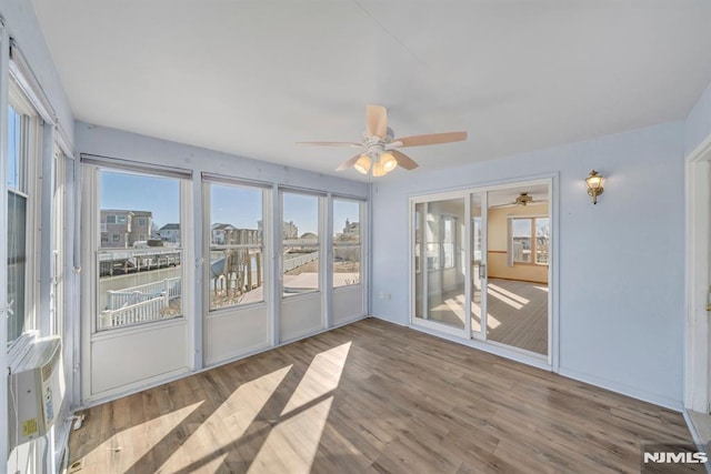 unfurnished sunroom with ceiling fan