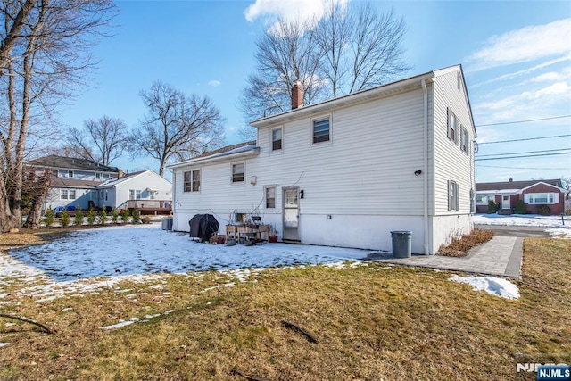 snow covered property with a lawn