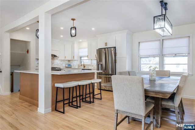 dining area with sink and light wood-type flooring