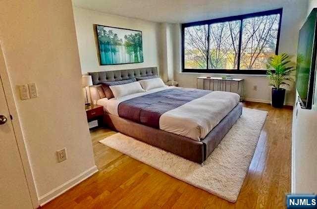 bedroom featuring wood-type flooring and radiator