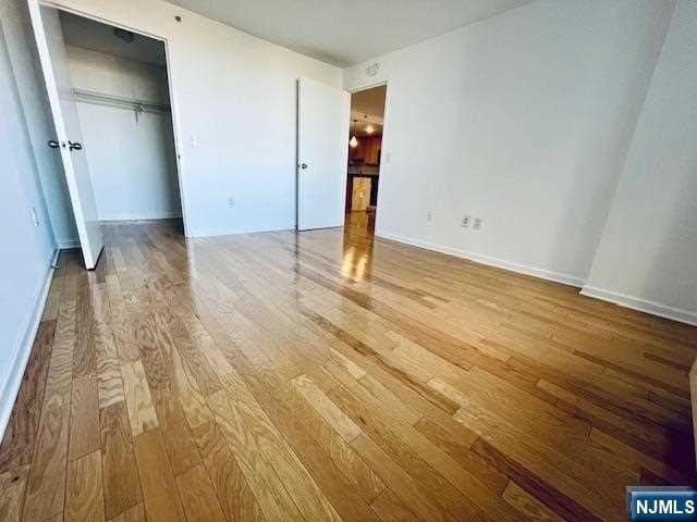 unfurnished bedroom with hardwood / wood-style flooring and a closet