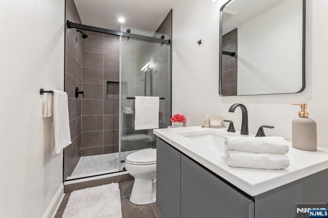 bathroom featuring vanity, walk in shower, and toilet