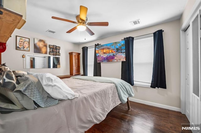 bedroom featuring ceiling fan, dark hardwood / wood-style floors, and a closet