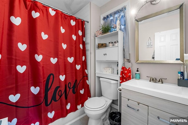 full bathroom featuring vanity, shower / tub combo with curtain, and toilet