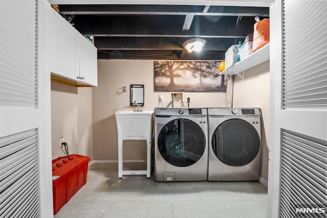 washroom with cabinets and washing machine and clothes dryer