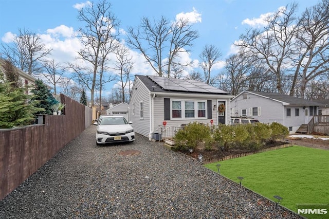 view of front facade featuring a front yard and solar panels