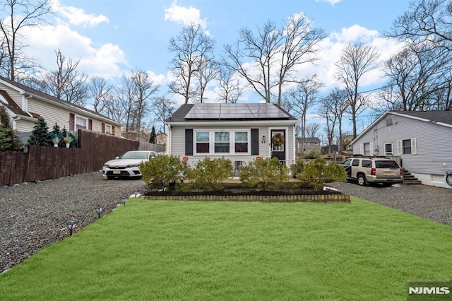 view of front facade with a front lawn and solar panels