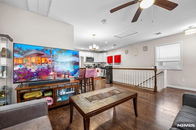 living room with dark hardwood / wood-style floors and ceiling fan with notable chandelier