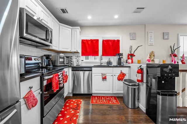 kitchen featuring white cabinetry, appliances with stainless steel finishes, sink, and dark hardwood / wood-style flooring