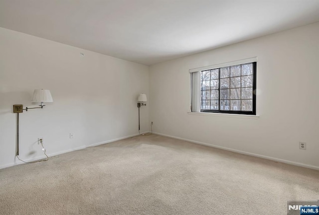 carpeted spare room with baseboards