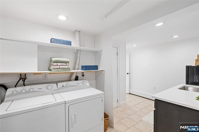 washroom featuring sink, light tile patterned floors, and washer and clothes dryer