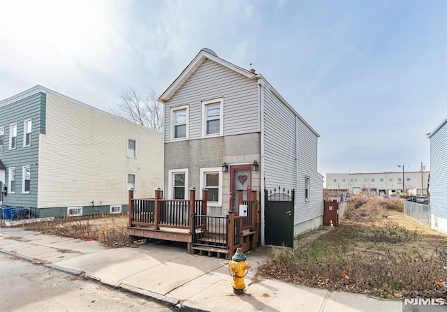 view of front of home with a wooden deck and cooling unit