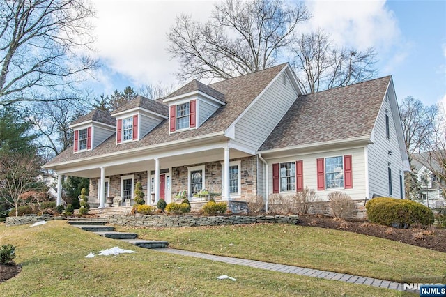 cape cod home with a front yard and a porch