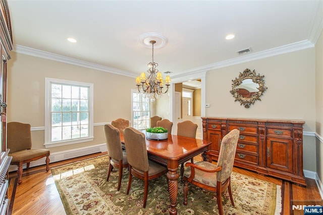 dining room with ornamental molding, a chandelier, baseboard heating, and light wood-type flooring