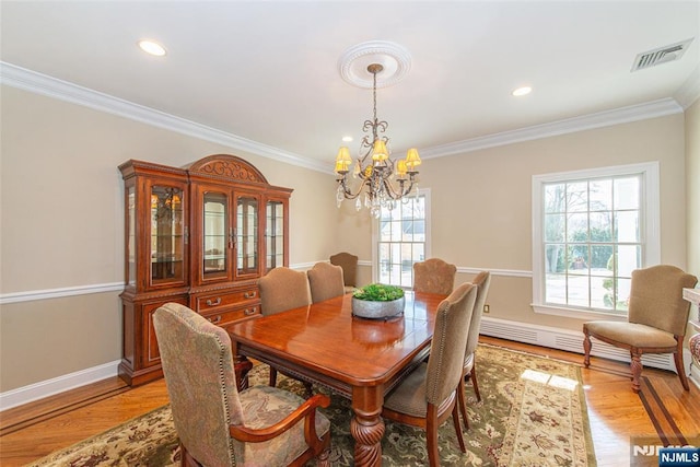 dining room featuring crown molding, an inviting chandelier, light hardwood / wood-style floors, and baseboard heating