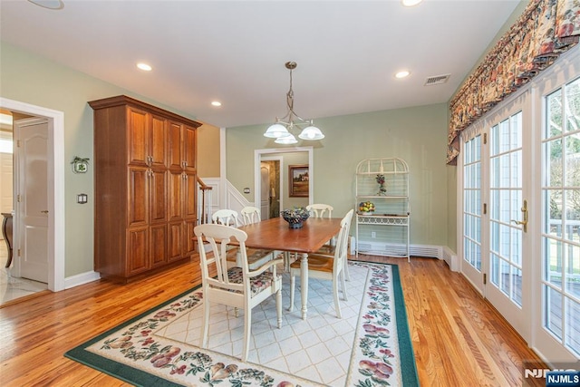 dining area with an inviting chandelier and light hardwood / wood-style flooring