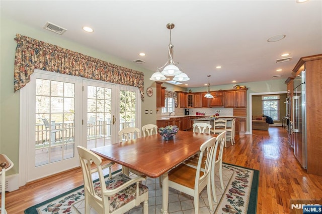 dining room with wood-type flooring, sink, and french doors