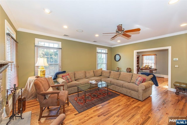 living room with ornamental molding, plenty of natural light, and light hardwood / wood-style floors