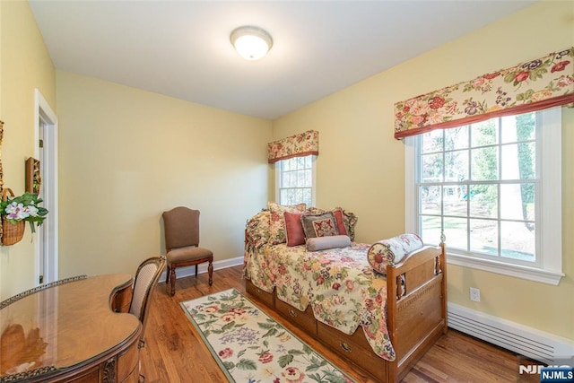 bedroom featuring wood-type flooring and baseboard heating